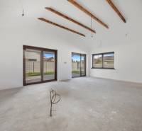 The interior of a family house with white walls and wooden beams on the ceiling.