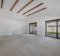 A spacious room with beams and windows to the terrace in a family house.