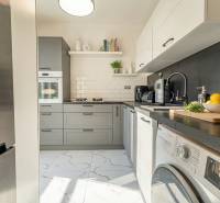 Kitchen in a 2-room apartment, gray cabinets, stone countertop, appliances.