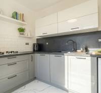 A kitchen in a 2-room apartment with modern equipment and light tiles.