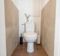 A toilet in a 2-room apartment with tiles and decorative elements.