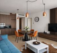 Living room with a sofa, dining table, and kitchen in a two-room apartment, floor with wood decor.