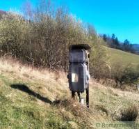 Plots - housing in Vydrná: Electrical switchboard on a meadow with a forest background.