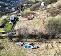Residential plots in Vydrná with a view of the hilly landscape and houses.