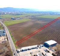 Agricultural and forest lands in Štúrovo with extensive flat areas and an adjacent road.
