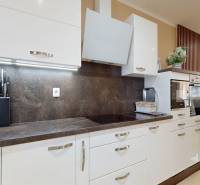 A kitchen in a family house with white cabinets and a dark countertop.