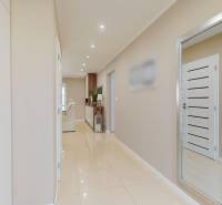 A hallway in a family house with white doors and built-in wardrobes.