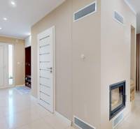 Interior with a fireplace and light walls in a family house, entrance hall, dining room.