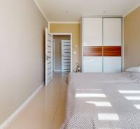 A bedroom in a family house with a built-in wardrobe and a comfortable bed.