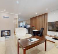 Living room in a family house with a fireplace, TV, sofa set, and dining table.