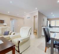 Living room in a family house with a white sofa and a table with flowers.