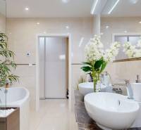 A bathroom in a family house with stylish furnishings, a large mirror, and flowers.