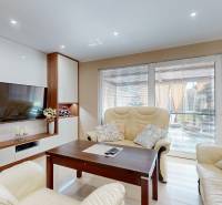 Living room in a family house with leather sofas and a television on the wall.