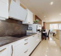 A kitchen in a family house with white cabinets and dark countertops.