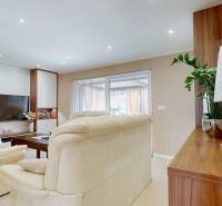 A comfortable living room in a family house with cream furniture and a television.
