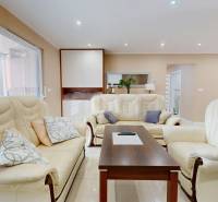 Living room of a family house with a cream sofa set and a wooden table.