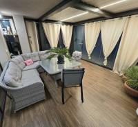 Winter garden in a family house with a sofa and wooden decor flooring.