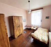 A room in a family house with a wooden decor floor, furniture, and a chandelier.