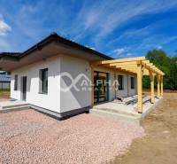 A family house in Harichovce with a terrace and a gravel yard, surrounded by greenery.