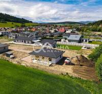 Construction work at a family house in Harichovce, surrounded by green nature and neighboring houses.