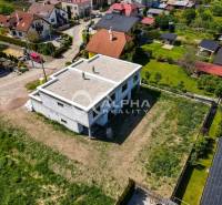 Aerial view of an unfinished family house in Harichovce with a spacious plot of land surrounding it.