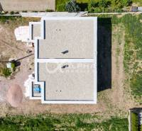 Construction of a family house in Harichovce, aerial view, with vacant plots around the construction site.