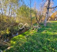 Residential plots by the stream and trees in Spišské Podhradie.