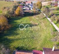 Residential plots in Spišské Podhradie surrounded by greenery and nearby houses.