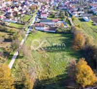 An aerial view of residential plots in Spišské Podhradie surrounded by houses and greenery.