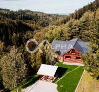 A family house in Hnilčík, surrounded by forests with a large grassy area and a gazebo.