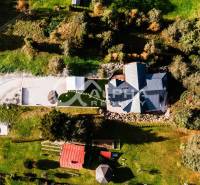 Aerial view of a family house in Hnilčík surrounded by greenery and an access road.