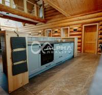 A kitchen in a family house with a wooden decor floor and wooden walls.