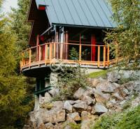 A wooden family house in Hnilčík surrounded by rocks and nature.