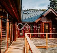 A family house in Hnilčík with a wooden terrace surrounded by nature and forest.