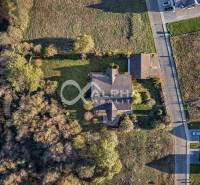 A family house in Veľká Lomnica surrounded by greenery and neighboring plots from a bird's eye view.