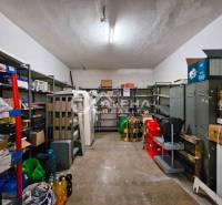 Room with shelves, metal cabinets, and various items on a wooden-decorated floor.