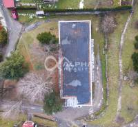 An aerial view of a building in Helcmanovce surrounded by trees and driveways.