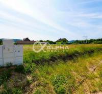 Plots - housing in Betlanovce with greenery, houses, and electrical cabinets in the background.