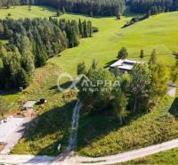 The hilly landscape in Spišské Vlachy, surrounded by greenery and houses, is suitable for residential plots.
