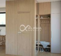 Interior with wood-patterned flooring, minimalist furniture, a wardrobe, and shoe racks.