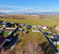 Exterior in Spišské Tomášovce, plots - residential, with a view of the surrounding fields and houses.