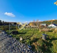 A plot for residential use in Markušovce, surrounded by nature, with visible houses in the background.