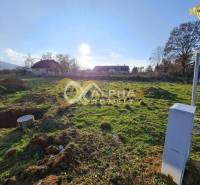 Plots - residential in Markušovce, grassy area with a view of the surrounding houses and trees.