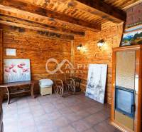 A family house with decorative wooden walls, a tiled stove, and artworks on the walls.