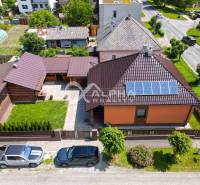 A family house in Spišská Nová Ves with solar panels and an adjacent garden.