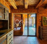 A wooden interior of a family house with rustic furniture and a view of the yard.