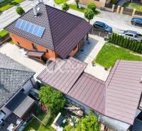 A family house in Spišská Nová Ves with a lawn and solar panels on the roof.