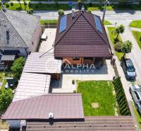 A family house in Spišská Nová Ves with solar panels and a landscaped garden.