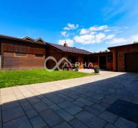 A family house in Spišská Nová Ves with a large paved terrace and a grassy area.