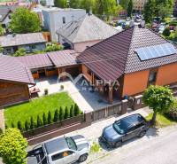 A family house in Spišská Nová Ves with panels on the roof and a well-maintained front garden.